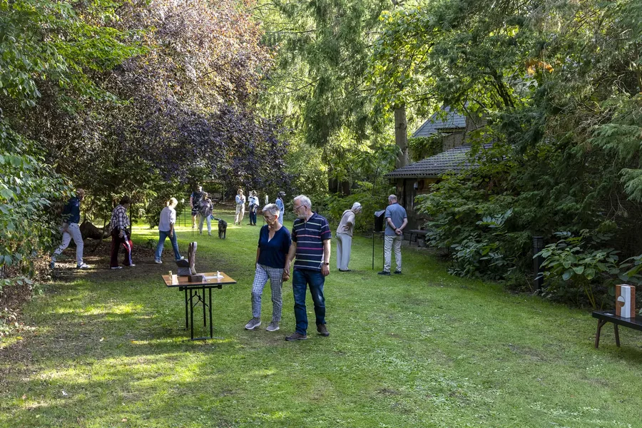 Bezoekers in een tuin tijdens KunsT met een grote T